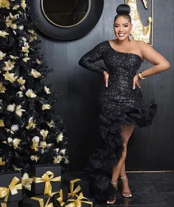 Detailed view of black one-shoulder sequin dress with irregular mesh ruffle hem