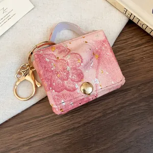 Dettaglio del ciondolo mini borsa in pelle rosa con motivo a cuore e gancio dorato