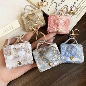 Vista dettagliata di cinque portachiavi in pelle stampata a fiori con accenti dorati
