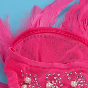 Detailansicht eines pinkfarbenen Netzkleides mit Federn, Strasssteinen und Perlen.