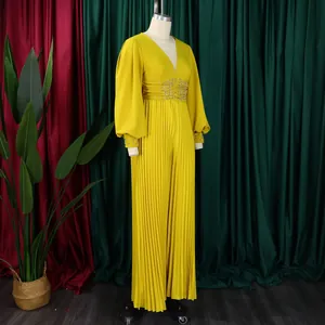 Detailed view of yellow pleated wide leg jumpsuit featuring beaded waist and bubble sleeves