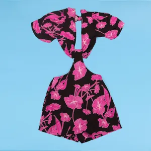 Detailed macro view of black floral cut-out romper with vibrant pink prints and ruffles.