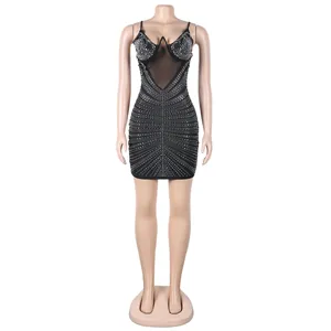 Vista detallada de un sexy mini vestido ajustado negro con pedrería sobre un maniquí de pie