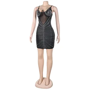 Detalle de un sexy vestido corto negro con pedrería e inserto de malla en el pecho