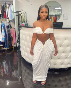 Detail view of a white pleated two-piece set with a strapless crop top and long skirt
