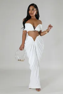Detail view of a white two-piece ruched maxi skirt and off-shoulder crop top set