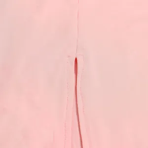 Primo piano della delicata trama in rete rosa trasparente e dettaglio spacco dell'abito