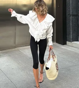 Full body view of model walking in black high-waisted cropped yoga leggings on city street