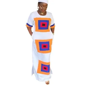 Vestido largo blanco de corte recto con estampado geométrico y aberturas laterales.