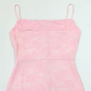 Detailed close-up of pink floral lace fabric on a sexy camisole slit dress for women