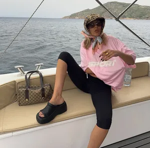 Lifestyle view of a woman wearing high-waisted black cropped yoga pants on a boat.