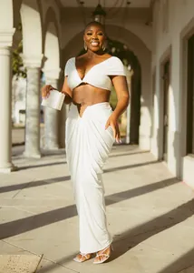 Elegant white two-piece set featuring off-shoulder crop top and draped long maxi skirt