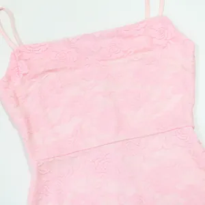 Close-up detail of elegant pink floral lace fabric on a camisole dress for women