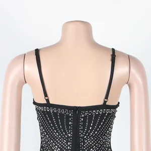 Vista detallada de la espalda de un vestido negro sexy con pedrería y patrón de tachuelas plata