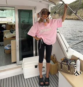 Premium lifestyle view of black high-waist 3/4 yoga leggings worn on a luxury yacht deck
