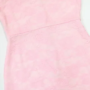 Close-up of elegant pink floral lace fabric texture on a sexy suspender long dress