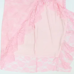 Close-up detail of the elegant pink rose lace fabric and soft inner lining on a ruffle dress.