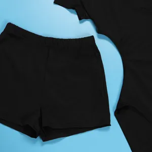 Close-up detail view of a black stretchy cutout two-piece set on a light blue background.