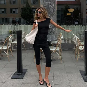 Stylish black high waist cropped yoga pants worn by a model in a modern street setting