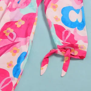 Detail view of colorful abstract floral print fabric with adjustable hem tie knot.