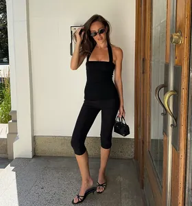 Close-up of black high-waisted cropped yoga leggings on model in street setting