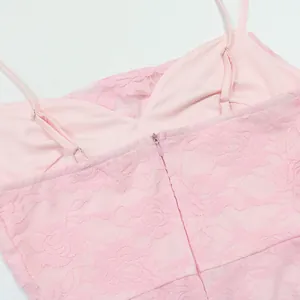 Close-up detail of a pink lace dress featuring adjustable straps and a back zipper closure.