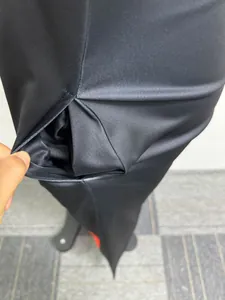 Vista detallada de la elegante abertura lateral negra en un vestido maxi largo y suelto.
