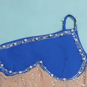 Dettaglio di strass scintillanti e perle bianche su rete trasparente e tessuto blu scuro