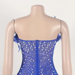 Detailansicht eines blauen Bodycon-Kleides mit Federn, Perlen und Strasssteinen.