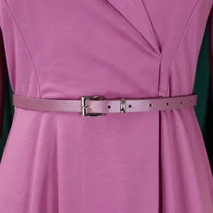 Detail of pink V-neck maxi dress featuring a high waist with a matching belt and buckle.