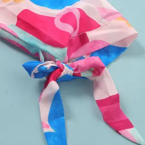 Detail of colorful abstract print dress with a stylish front tie-knot design.