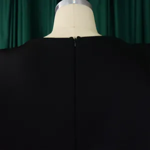 Detailed back view of an elegant black dress featuring a hidden zipper on a mannequin