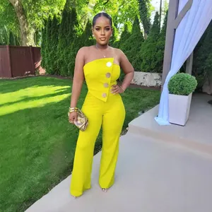 Ganzkörperansicht eines Models in einem leuchtend gelben, trägerlosen Jumpsuit im Garten
