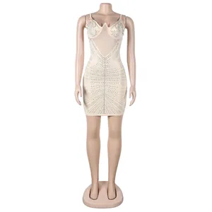 Vestido corto sexy beige ajustado con pedrería brillante en un maniquí de costura