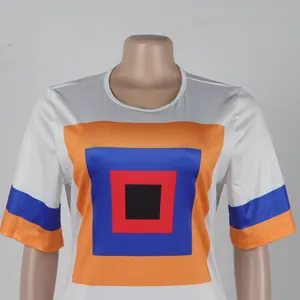 Detalle del estampado geométrico colorido en vestido blanco suelto con abertura lateral
