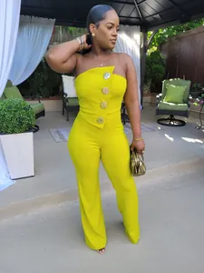 Elegante gelbe trägerlose Jumpsuit mit großen goldenen Zierknöpfen in Vollansicht