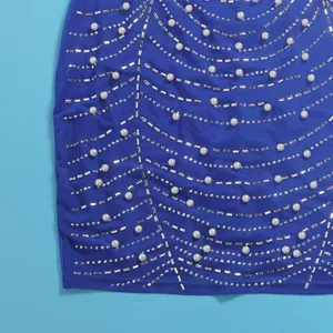 Detailaufnahme des blauen Kleiderstoffs mit weißen Perlen und silbernen Strasssteinen