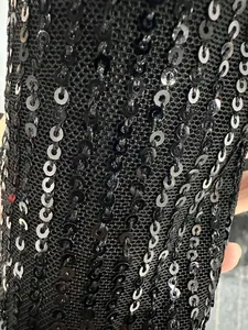 Close-up of black sequined mesh fabric showing shimmering detail and texture