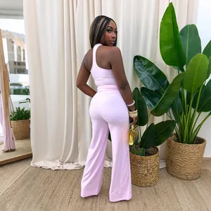 Vista posteriore di un elegante top rosa monospalla e pantaloni a gamba larga