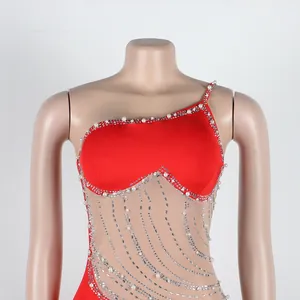 Primo piano di abito sexy rosso monospalla con inserti in rete, perle e strass luccicanti