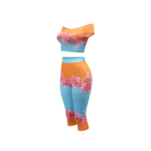 Detail of vibrant floral print on orange and blue two-piece crop top and pants set