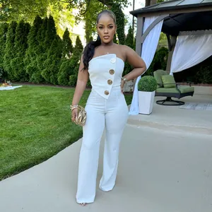 Eleganter weißer trägerloser Jumpsuit mit weitem Bein und goldenen Zierknöpfen.