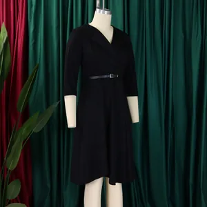 Side view detail of a black V-neck high-waisted midi dress with a flared skirt and belt.