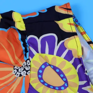 Close-up of vibrant floral print fabric and stitching on a ruffle sleeve jumpsuit.