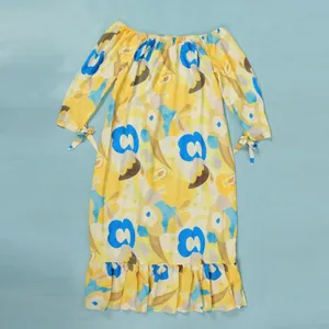 Detailed view of off-the-shoulder floral print dress with ruffled hem and tied cuffs.