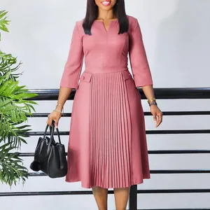 Robe midi rose élégante avec plis accordéon sur le devant et manches trois-quarts.