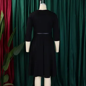 Back view of an elegant black high-waisted dress with a flared skirt on a mannequin.