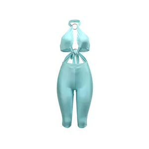 Vista dettagliata di una tuta azzurra con scollo all'americana e anelli metallici alla moda.