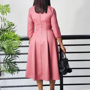 Vue arrière détaillée d'une élégante robe mi-longue plissée rose poudré à manches 3/4