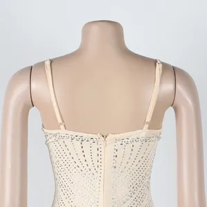 Exquisito detalle trasero de un vestido beige con pedrería con tirantes finos y cremallera